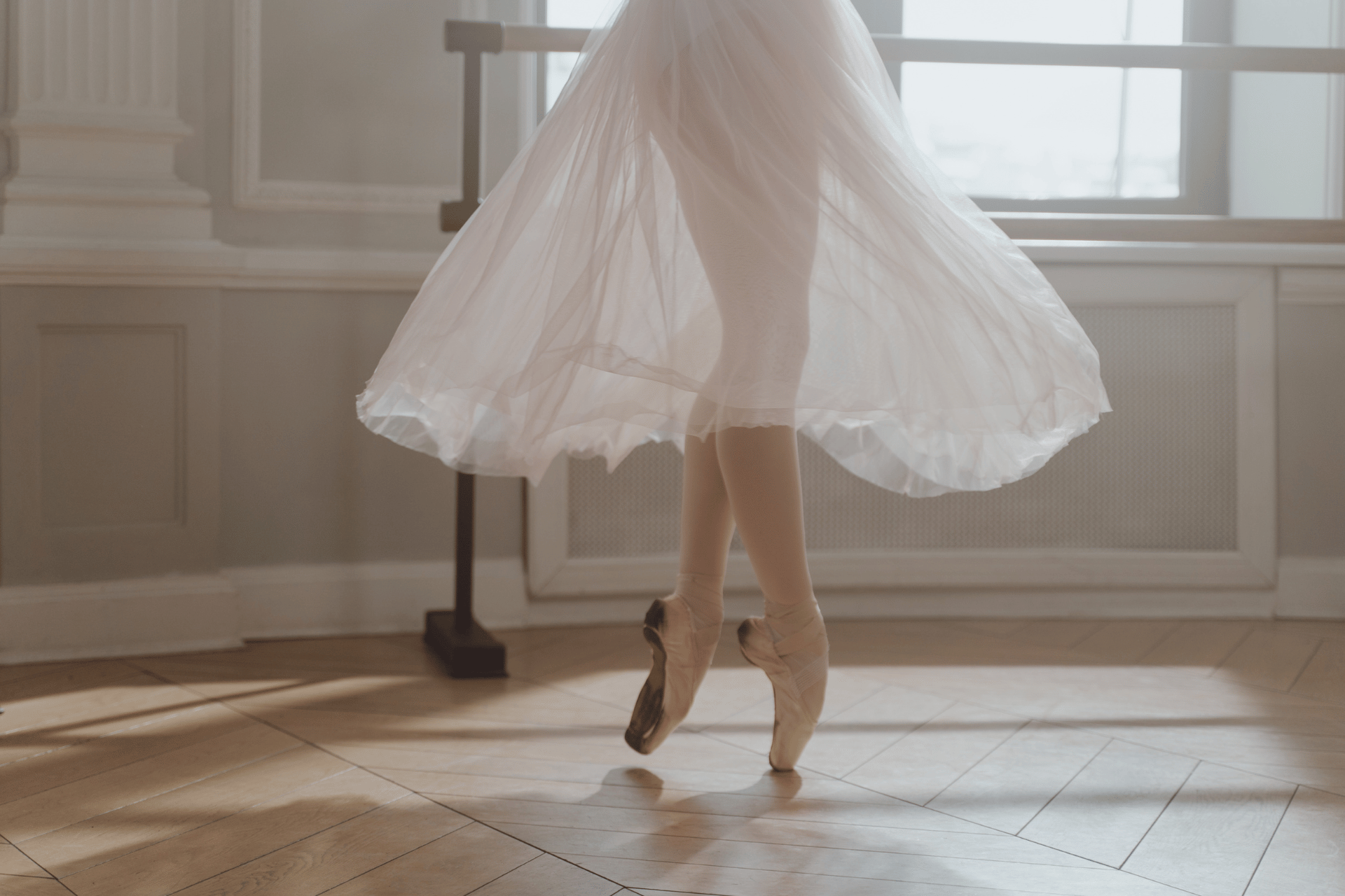 ballerina in a white outfit on dance floor