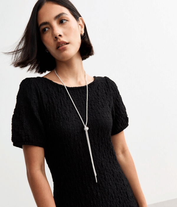 image of woman wearing a black top and long necklace