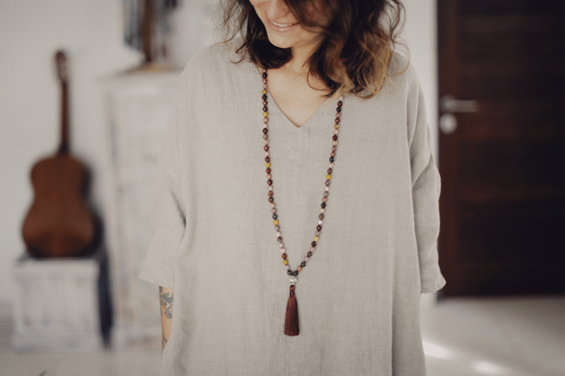 image of woman in beige top wearing a long necklace