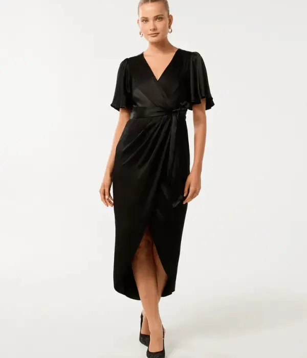 model wearing a wrap dress with a high low hem on grey background