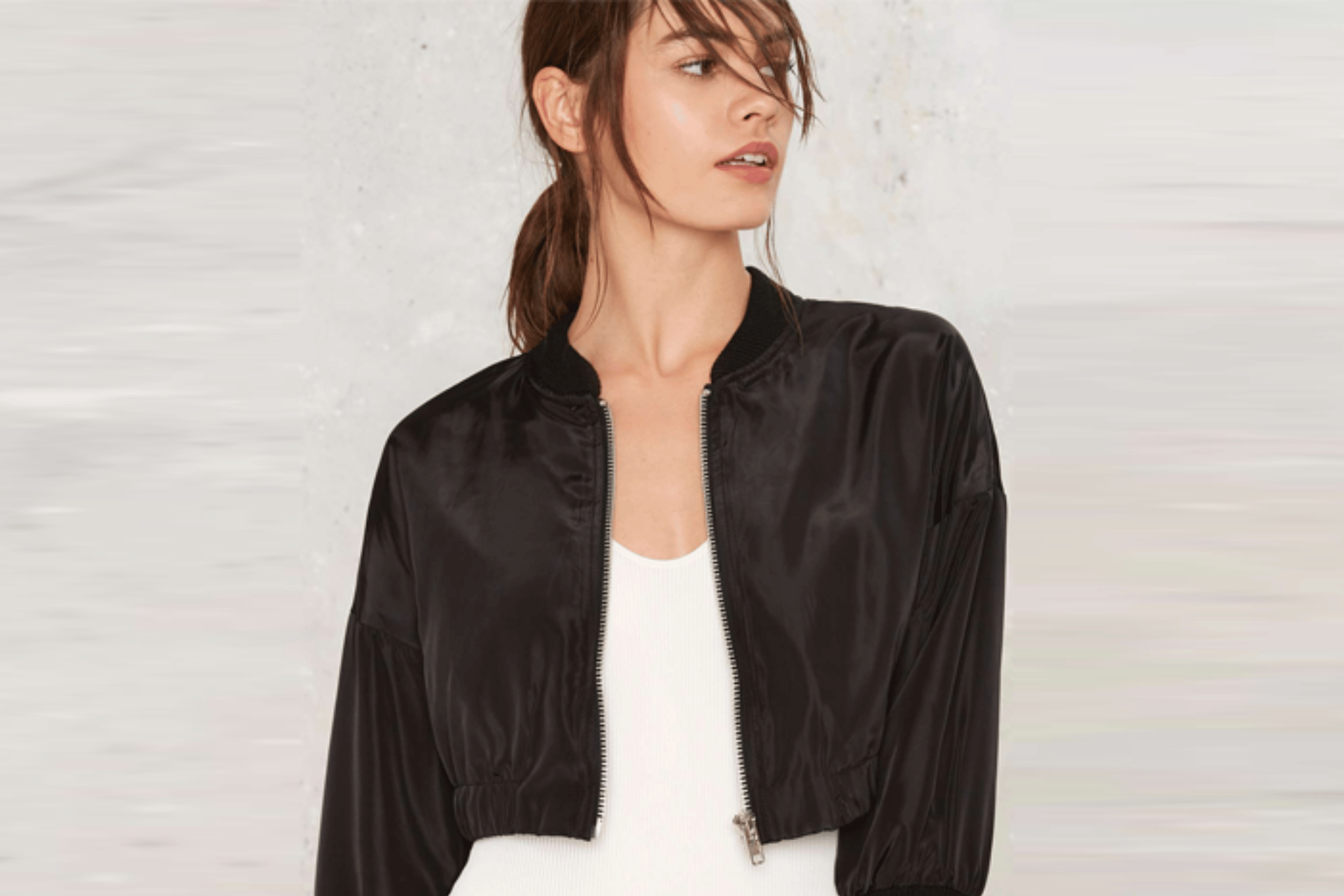 model wearing a white top and black short bomber jacket