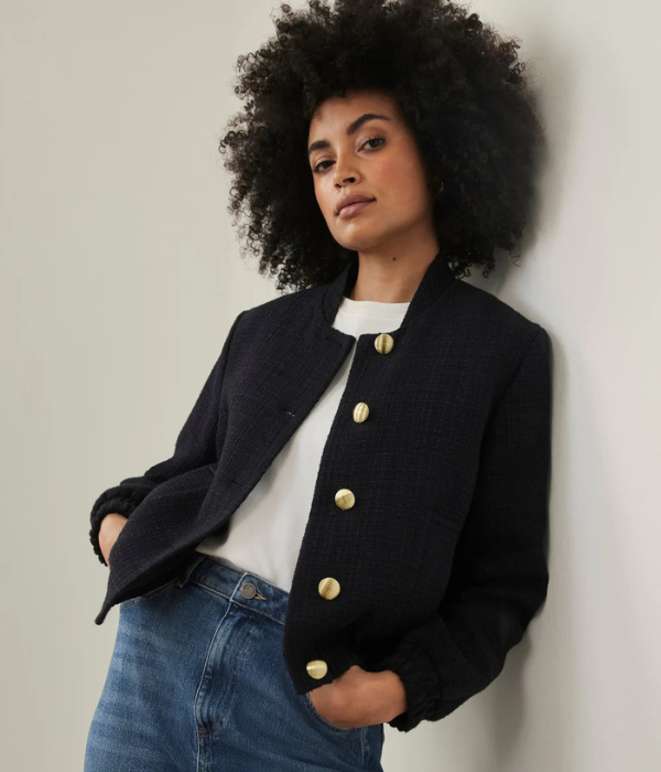 dark haired model wearing navy blue bomber jacket denim skirt and white t-shirt
