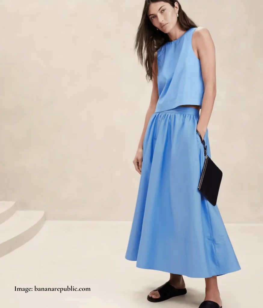 model wearing blue gathered skirt and blue top cropped at the waist