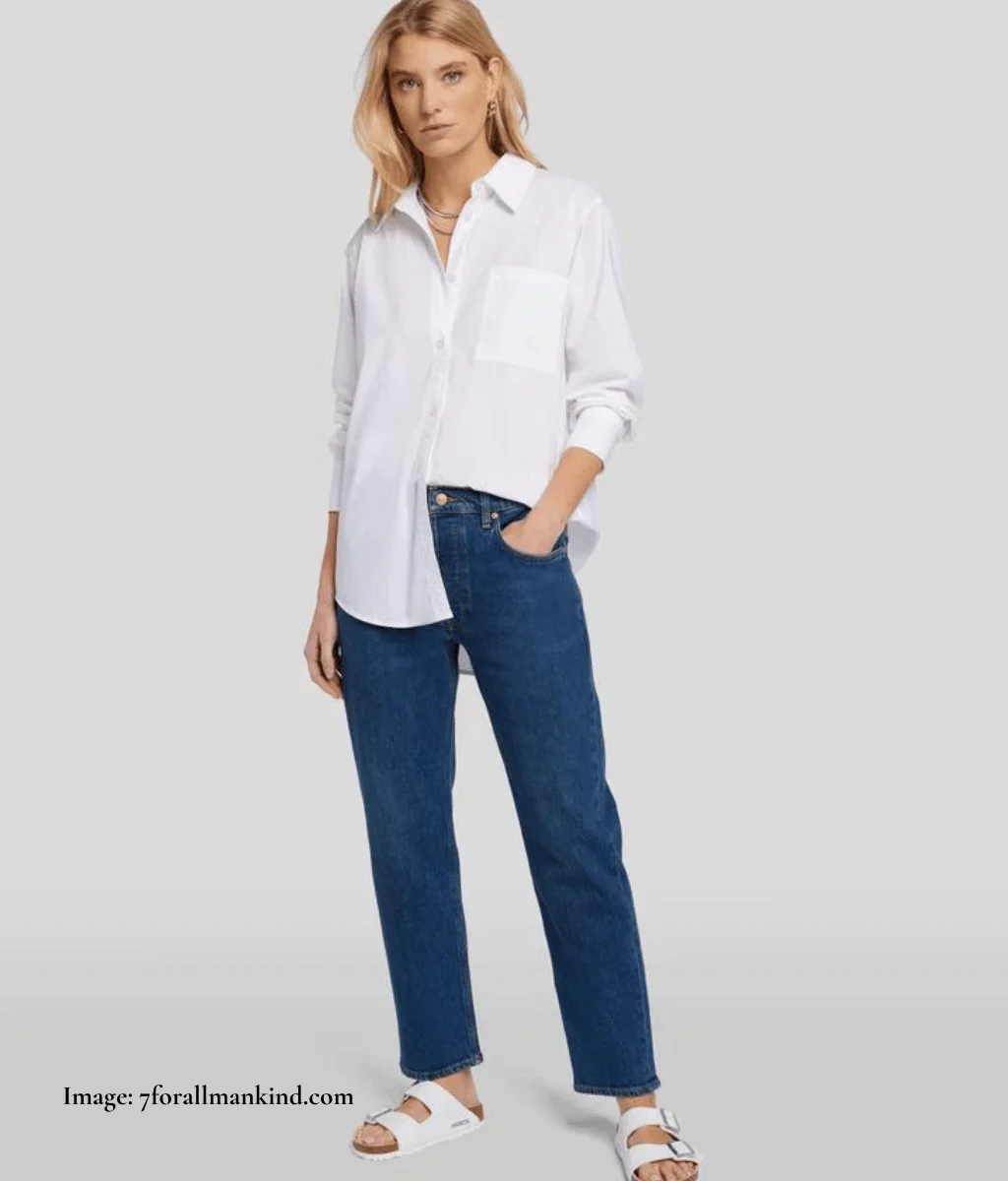 model wearing dark boyfriend jeans with a white shirt tucked in on one side, tucked out on the other side
