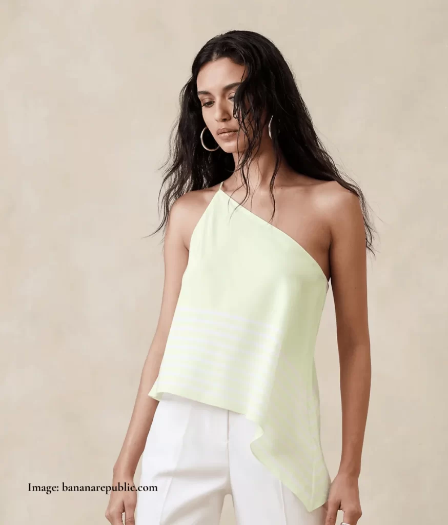 model wearing a yellow asymmetric one shoulder top and white pants