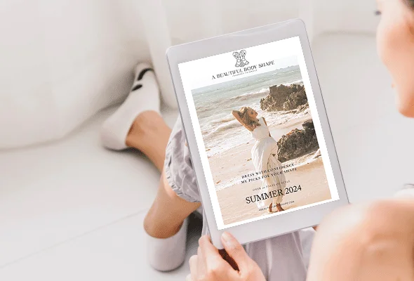 girl sitting on a white lounge looking at a beautiful body shape magazine on her tablet