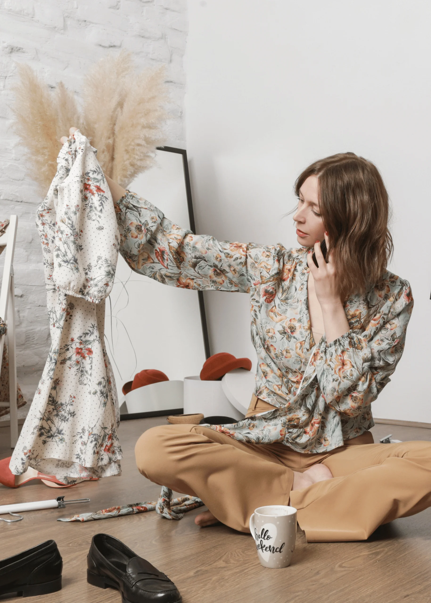 woman sitting on the floor holding up a dress