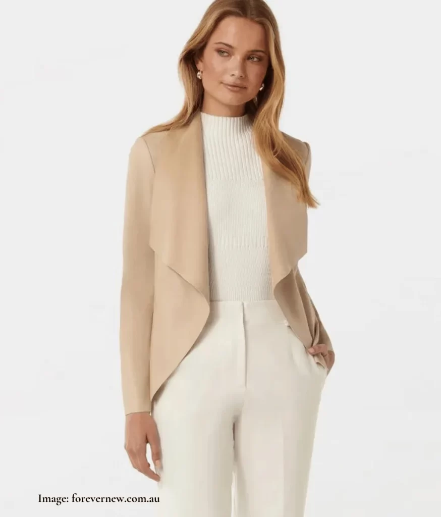 model wearing a beige waterfall jacket, white top and white pants