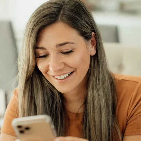 woman looking at phone and smiling